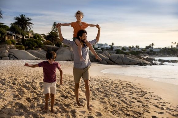 Pai brincando com os filhos na praia