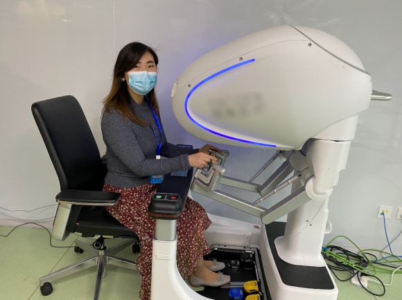 image 2 : Healthcare analyst Cui Cui is trying out a Chinese-made surgical robot during a company visit.