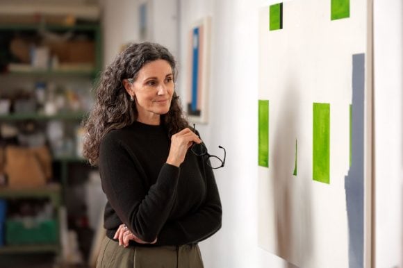 Woman looking at painting in art studio