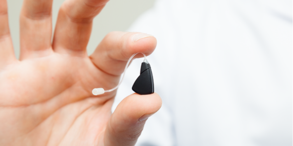 close up of man holding hearing aid