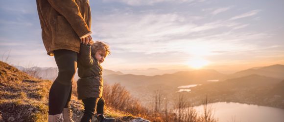 Mother with child on mountain top overlooking Lake Lugano