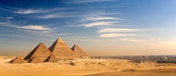 View of the Pyramids of Giza across the desert landscape.