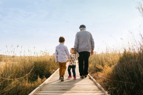 Old man walking with 2 children