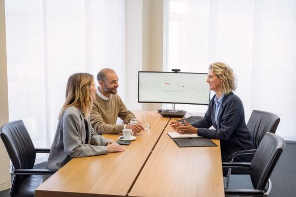 Consultant talking to a couple over a desk in a office