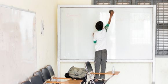 Student cleaning white board