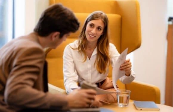 Consultant talking to a couple over a desk in a office