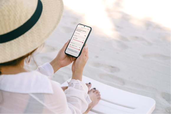 Donna sulla spiaggia usando il suo telefono