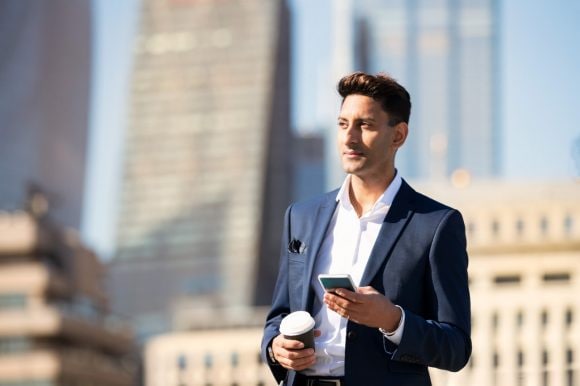 Man using phone and holding coffee