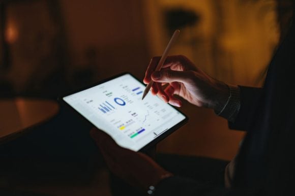 Professional reviewing charts and data visualizations on a computer screen.
