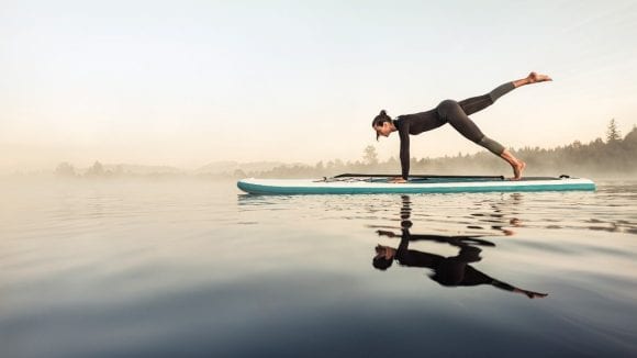Woman doing yoga on stand-up paddle board