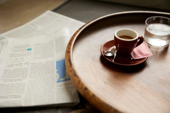 Un periódico y un café en una mesa 