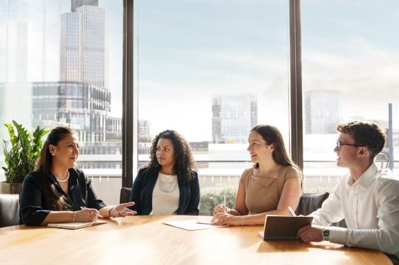 Team of individuals sat around table in london office