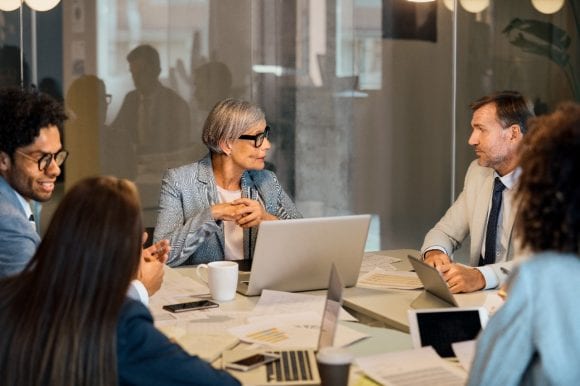 Business team meeting with laptops and paper documents