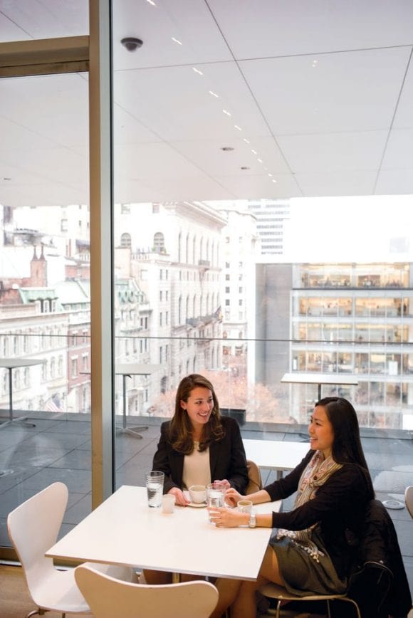  Two colleagues sitting at a table socializing.