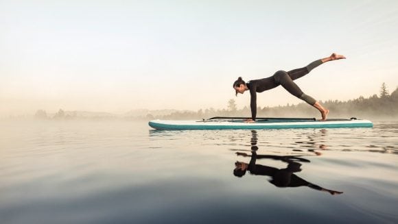 Woman doing yoga on stand-up paddle board