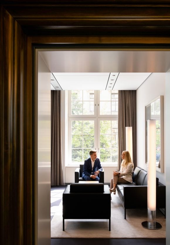 Una pareja profesional sentada en un descanso moderno bajo la luz del sol 