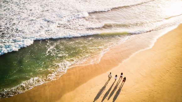 Familia paseando por la playa