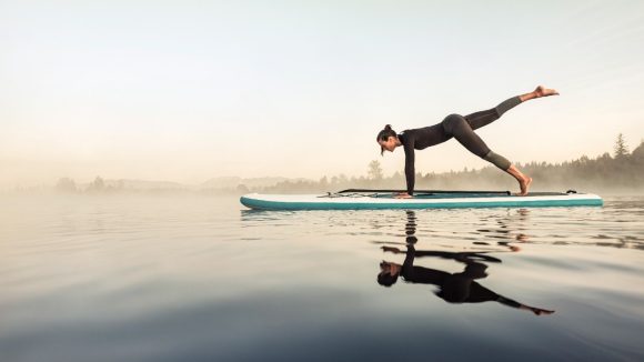 Woman doing yoga on stand-up paddle board