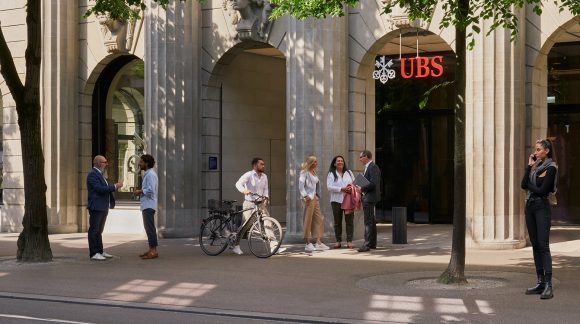 People standing outside a UBS office entrance