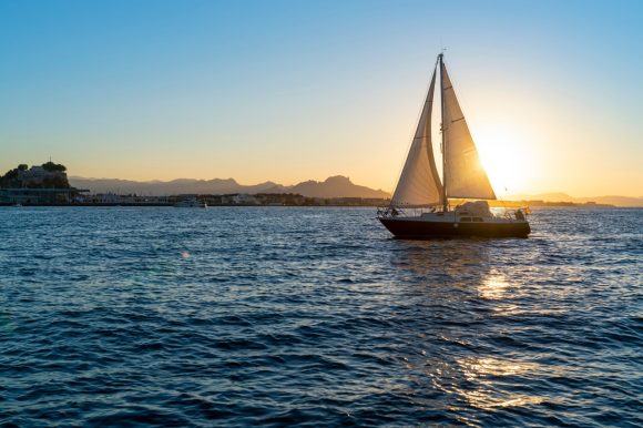 A boat is sailing at sunset