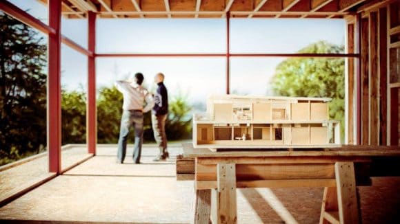 Two people inspecting the structure of a building