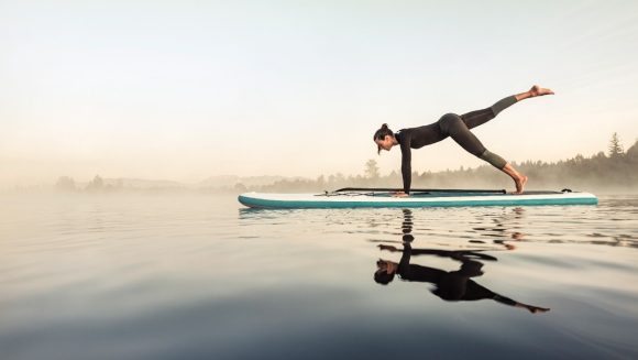 Woman doing yoga on stand-up paddle board