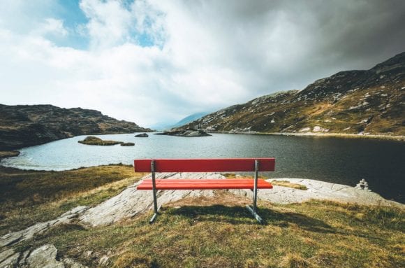 red bench with lake and mountains view