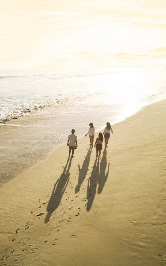 Four people walking on a Beach