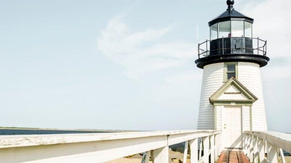 Dramatic shot of a lighthouse against a backgrop of an expansive beach