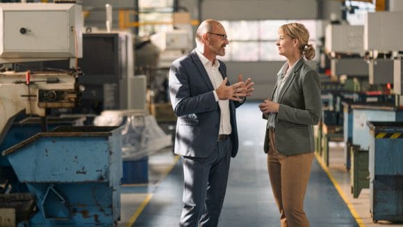 Colleagues discussing in a factory.