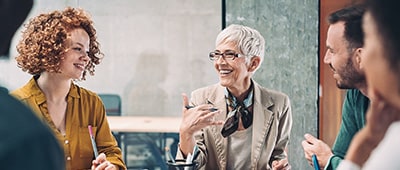 Woman Advisor smiling while leading a team meeting.