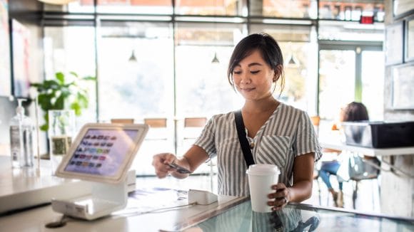 Young woman paying for coffee