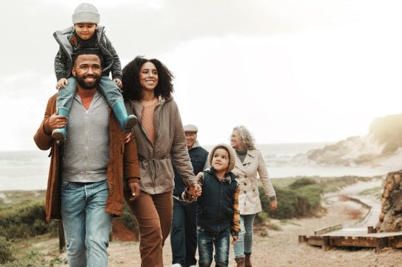 Grandparents, parents and children walking outdoors.