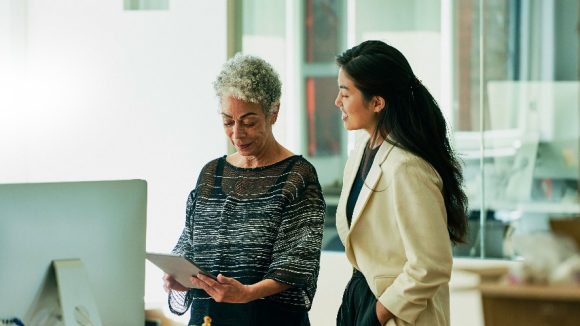 Businesswomen looking at digital tablet in office