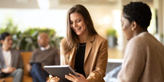 Two women having conversation in office space