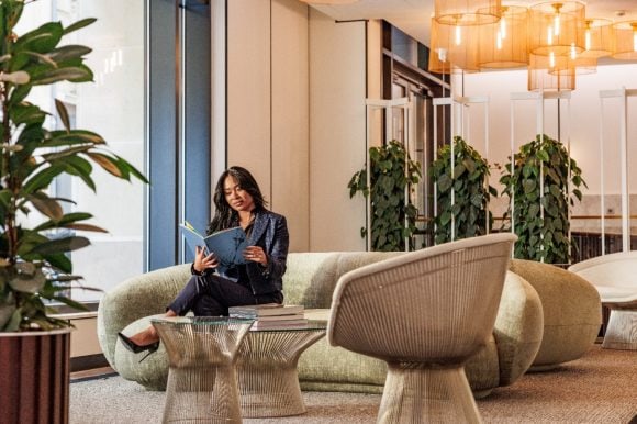 Woman reading book in lobby
