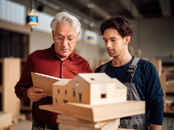 Father and son discussing architectural project at family business