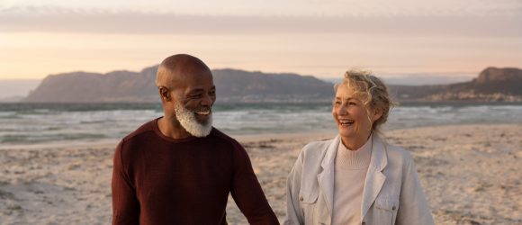 Close-up of retirement age couple laughing on the beach