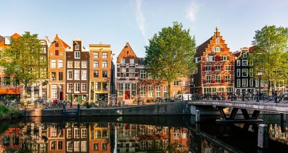Historic Dutch houses reflecting in canal, Amsterdam