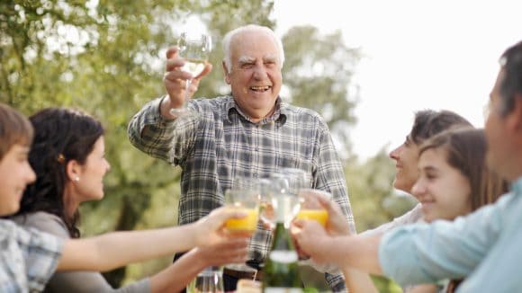 Family meal with grand dad toasting