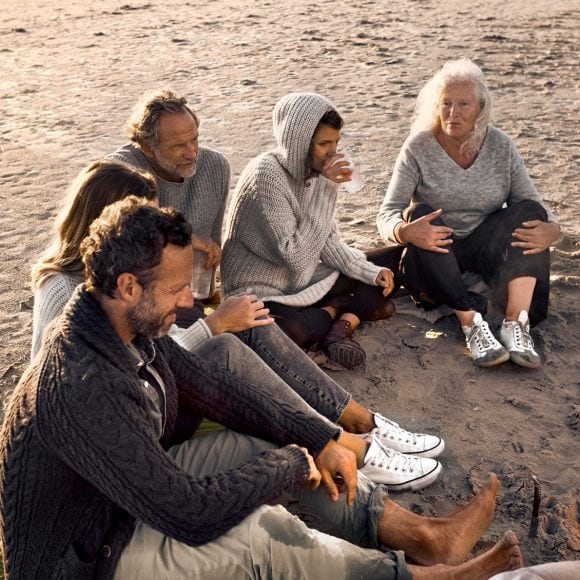 Three generations of family sitting on beach