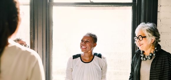 Senior businesswoman listening to colleague in office meeting