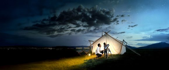 Father + daughter viewing night sky through telescope