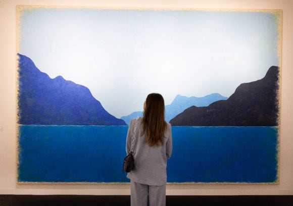 women looking at blue colored mountain art
