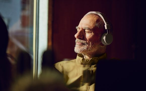 Senior man listening to music with headphones