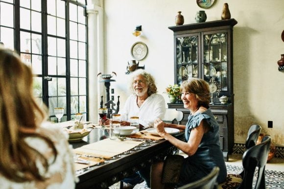 Smiling grandparents seated together at dining room table during celebration