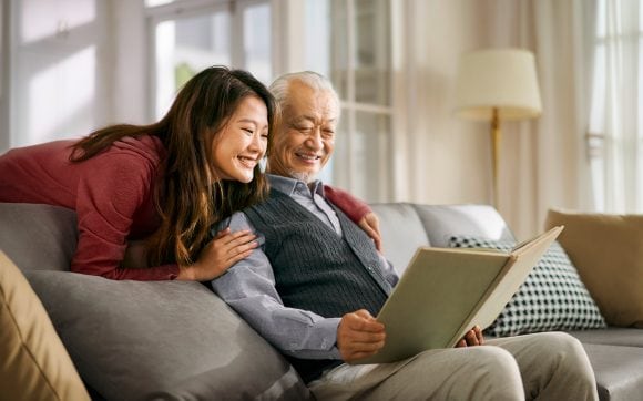 Senior father and daughter reading book together