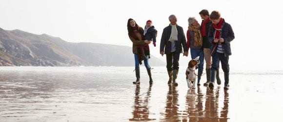 Multigenerational family walking on beach