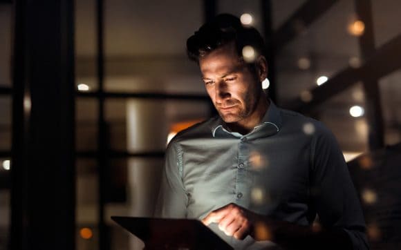 Businessman working with tablet at night