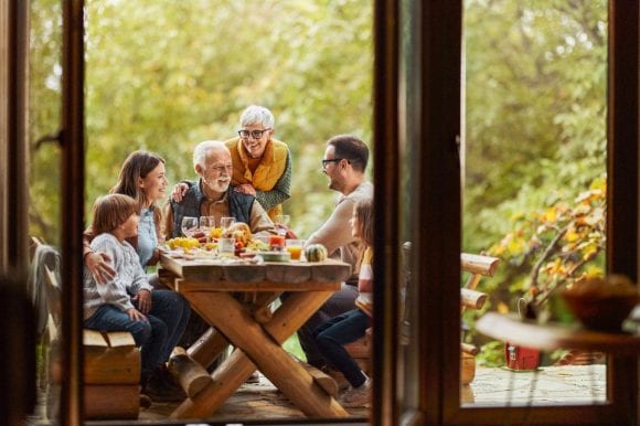 Multi-generation family having lunch on patio